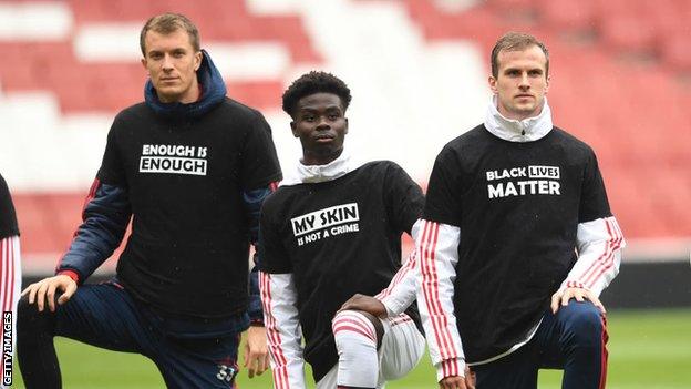 Matt Macey, Bukayo Saka and Rob Holding of Arsenal take a knee in support of Black Lives Matter before a friendly match between Arsenal and Brentford