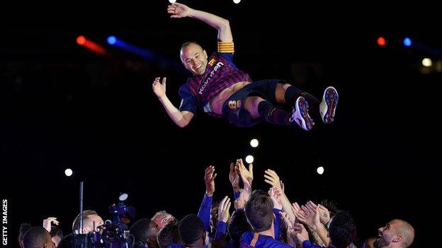 Andres Iniesta is thrown into the air by his Barcelona team-mates