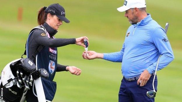 Lee Westwood gets hand sanitiser from caddie and girlfriend Helen Storey