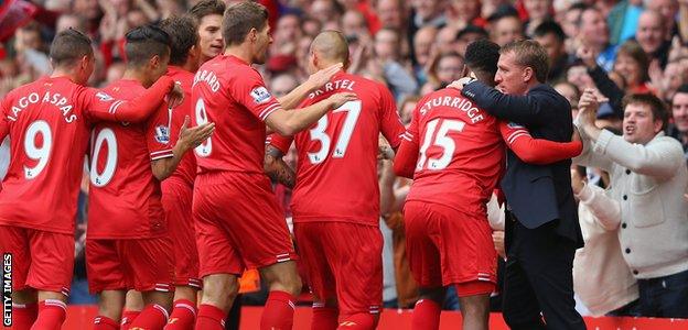 Brendan Rodgers hugs Daniel Sturridge as other Liverpool players celebrate after Sturridge scored the opening goal against Manchester United at Anfield in 2013