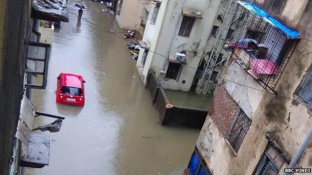 A car lies on a flooded Mumbai street