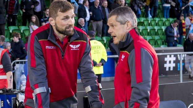 John Barclay watches from the sidelines on crutches with his foot in a protective boot