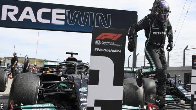 Lewis Hamilton jumps off his Mercedes after winning the race