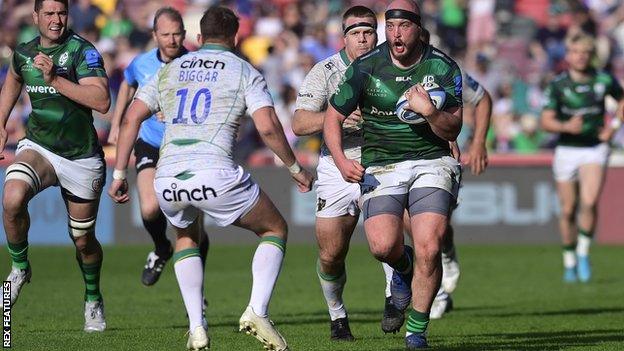 Ollie Hoskins of London Irish runs at Dan Biggar of Northampton Saints