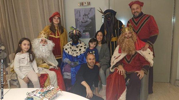 A photo of former Barcelona midfielder Andres Iniesta (centre) surrounded by his family and a group of people dressed in costumes to mark Three Kings Day, two of whom are in black makeup