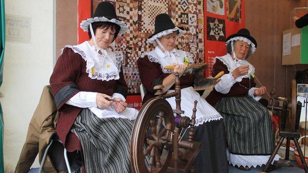 Maureen Preen (ar y dde), gydag Olwen Davies (canol) a Gwenno Jones, yn nyddu ar stondin Amgueddfa Cymru // Maureen Preen (right), with Olwen Davies (centre) and Gwenno Jones spinning a yarn on the National Museum of Wales stand