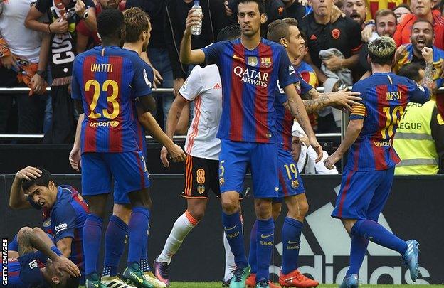 Barcelona players react after a bottle is thrown by a Valencia fan