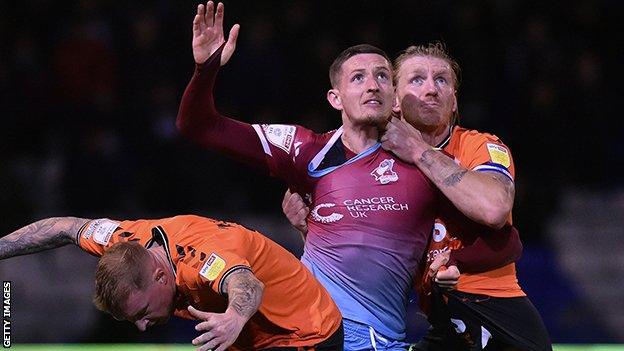 Oldham Athletic's Nicky Adams and Oldham Athletic's Carl Piergianni tussle with Ryan Loft of Scunthorpe United during the Sky Bet League 2 match between Oldham Athletic and Scunthorpe United at Boundary Park