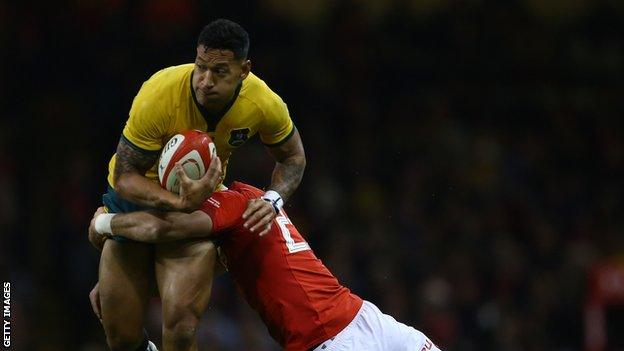 Israel Folau is tackled by a Wales player