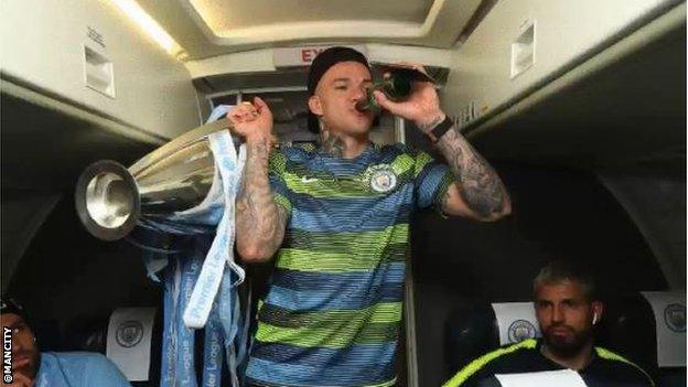 Ederson drinks beer while he holds the Premier League trophy