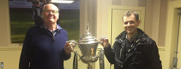 Beith president John Boal (left) lets Kenny Crawford get his hands on the Scottish Junior Cup