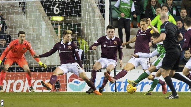 Jamie Maclaren sends a shot past a flurry of Hearts players to score Hibs' second goal