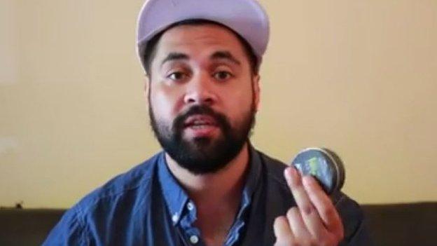 Actor Bjorn Stewart in “How to do blackface” makeup tutorial holding a pot of shoe polish