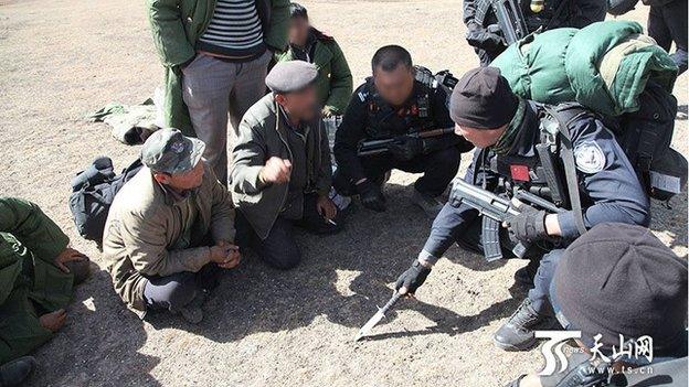 Chinese state media pictures show security forces searching a remote area of rugged terrain in Xinjiang