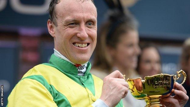 Robbie Power kisses the Gold cup after victory on Sizing John during Gold Cup Day of the Cheltenham Festival