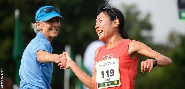 Benoit Samuelson (left) greets a runner at the finish of the 2018 Beach to Beacon 10km in Maine