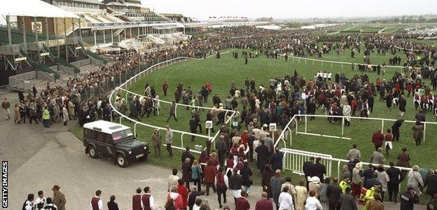 Crowds file on to the Aintree course after the IRA bomb scare which led to the National being postponed