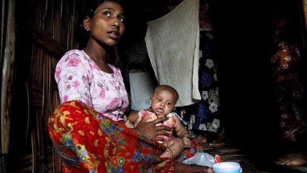 Rohingya woman holds her child in her room at the ThetKelPyin Muslim refugee camp in Sittwe, Rakhine State, western Myanmar