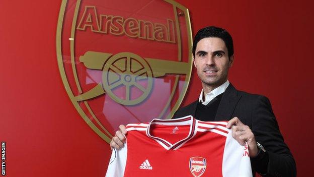 Mikel Arteta holding an Arsenal shirt after being appointed head coach