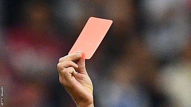 A referee showing a red card