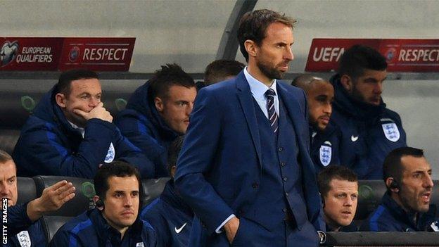 Gareth Southgate watches his England side as Wayne Rooney looks on from the bench