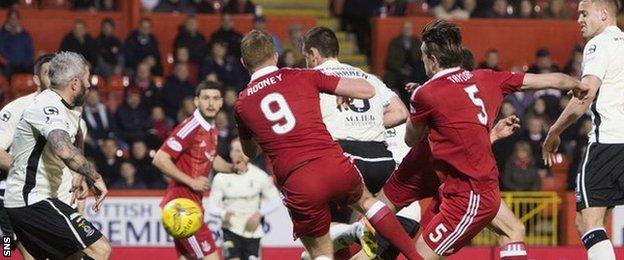 Gary Warren (centre) gets the final touch to direct the ball past his own goalkeeper