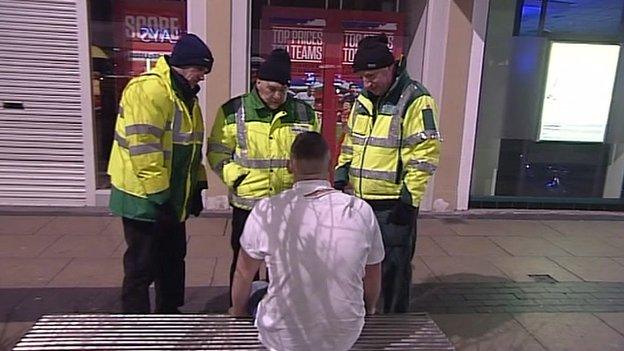 Paramedics attending a drunk man in the street