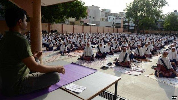 Indian school students attend a yoga workshop conducted by teachers from The Sri Sri Ravi Shankar Institute at The FD Higher Secondary School in Ahmedabad on June 16, 2015