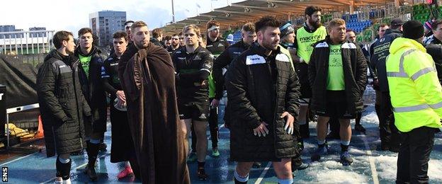 Glasgow Warriors players congregate off the field during the stadium evacuation