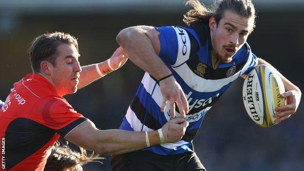 Max Clark of Bath is challenged by Chris Wyles of Saracens