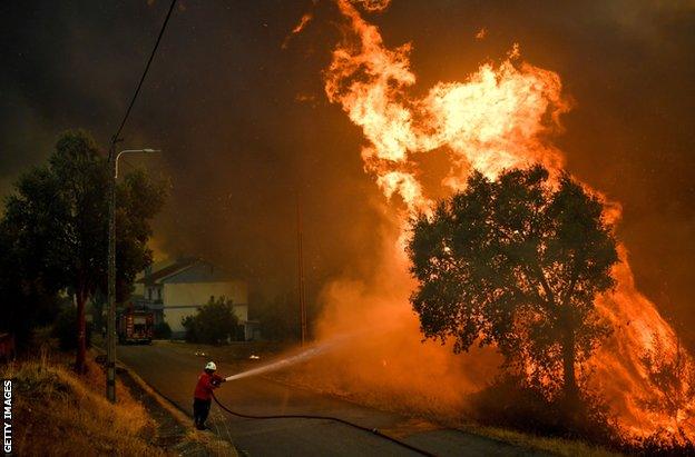 A firefighter tackles a wildfire close to the village of Pucarica in Abrantes on August 10, 2017