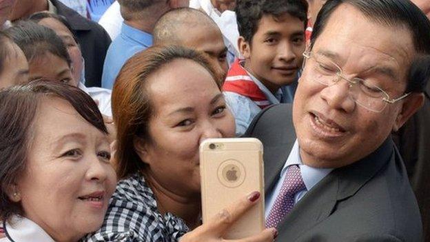 Hun Sen poses for a selfie with supporters during