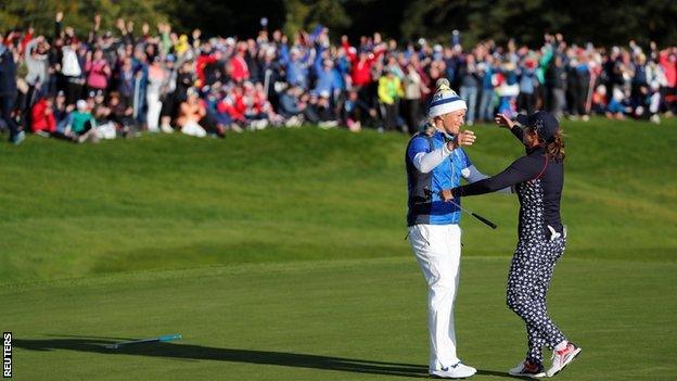 Suzann Pettersen consoles opponent Marina Alex on the 18th green after rolling in the putt to win the Solheim Cup