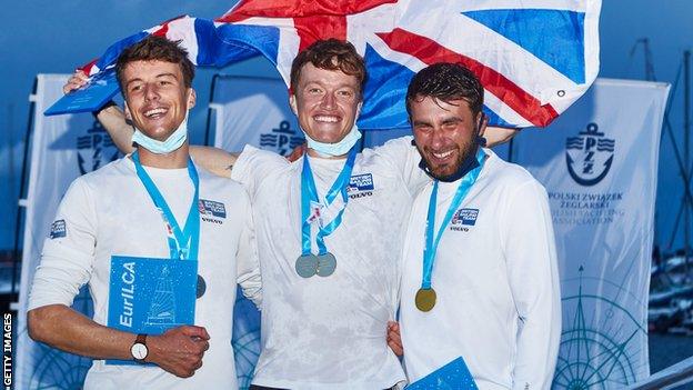 Elliot Hanson celebrates winning the European title with Michael Beckett and Lorenzo Chiavarini