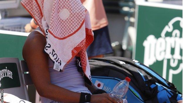 Naomi Osaka hides under her towel