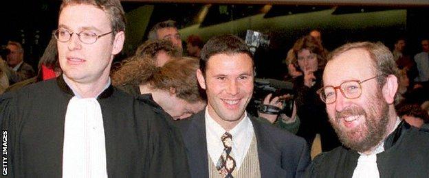 Belgian soccer player Jean-Marc Bosman, flanked by two of his lawyers Luc Misson (R) and Jean-Louis Dupont (L), smiles as the European Court of Justice rules 15 December 1995 that the transfer system of players between football clubs was illegal.