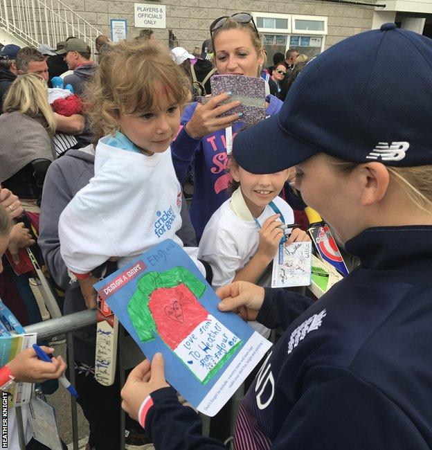 Heather Knight receives a picture from a mascot