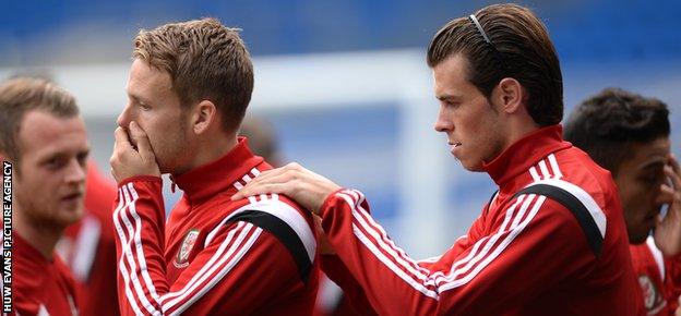 Chris Gunter gets a helping hand from Wales team-mate Gareth Bale in training