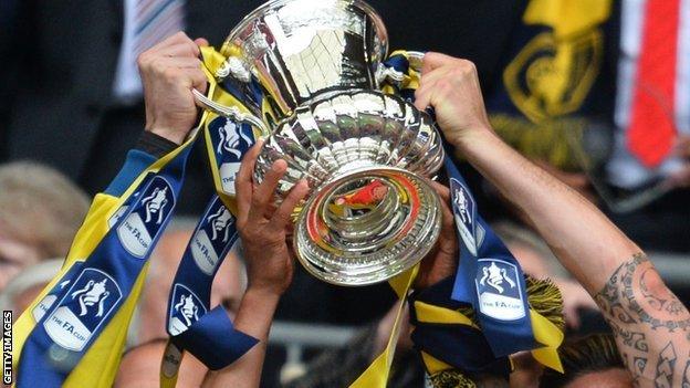 FA Cup trophy held aloft by Arsenal players