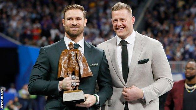 Chris Long holds the Walter Payton Award next to JJ Watt during Super Bowl 53