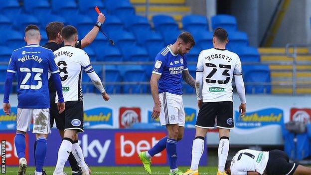 Joe Ralls trudges off after receiving a second booking for a foul on Korey Smith