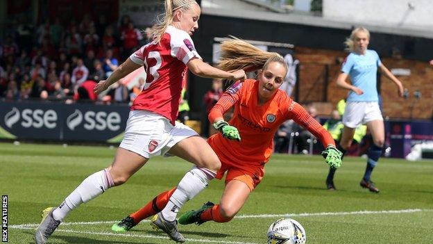 Manchester City goalkeeper Ellie Roebuck attempts to smother an effort from Arsenal striker Beth Mead