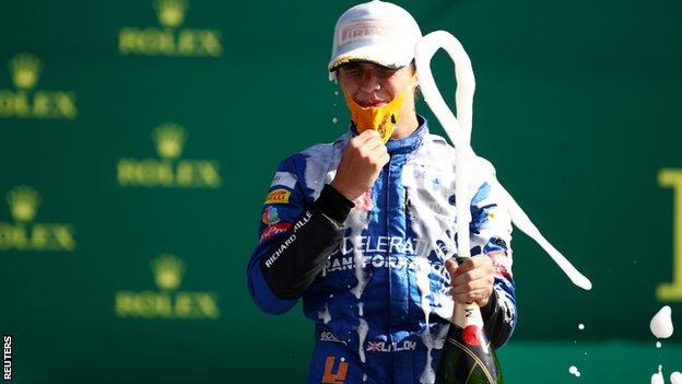 Lando Norris celebrates with champagne