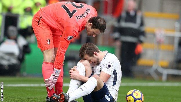 Asmir Begovic checks on harry Kane after their collision