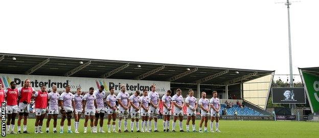 Players stand for the minute's silence at the Sale-Northampton game