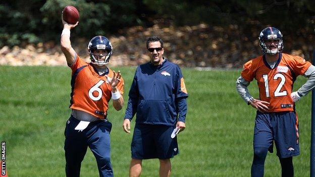 A man coaches a quarterback