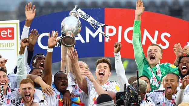 Fulham players celebrate with the trophy