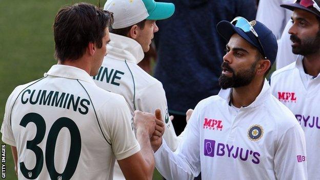 India's Virat Kohli (facing camera) fist bumps Australia's Pat Cummins (back to camera) on the third day of the first cricket Test match between Australia and India in Adelaide