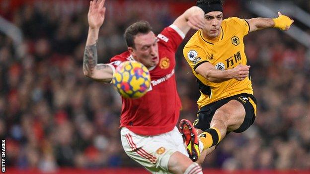 Phil Jones tries to block Raul Jimenez's shot
