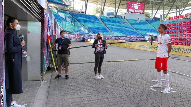 RB Leipzig striker Yussuf Poulsen is interviewed from a safe distance